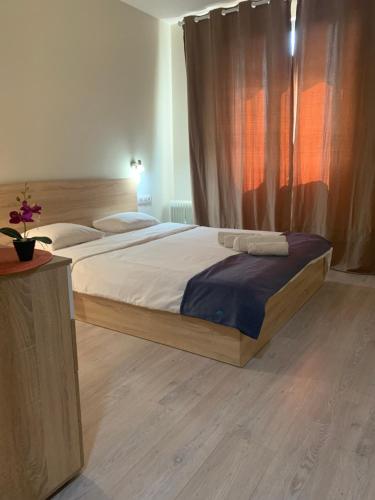 a bedroom with a large bed with a wooden frame at City Residence Apartments Sofia in Sofia