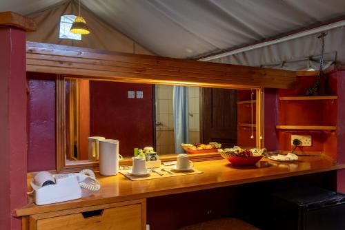 een kamer met een houten tafel en een spiegel bij Sentrim Amboseli Lodge in Amboseli