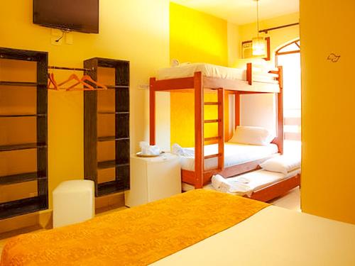 a room with two bunk beds and a tv at VELINN Pousada Casa de Pedra Ilhabela in Ilhabela
