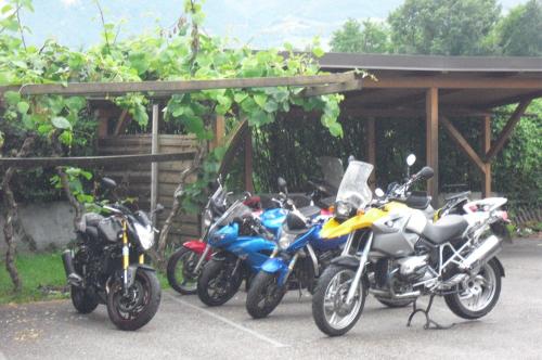 a row of motorcycles parked under a building at Dependance Villnerhof in Egna