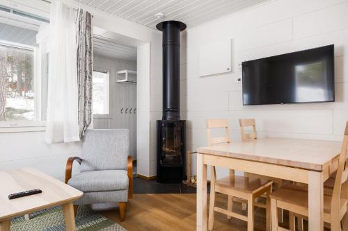 a living room with a table and a wood stove at Levilehto Apartments in Levi