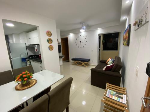 eine Küche und ein Wohnzimmer mit einem Sofa und einem Tisch in der Unterkunft Mirantes 59 Apto próximo à Ponta Negra e Cotovelo in Parnamirim