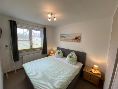 a small bedroom with a bed and a window at KapLuv Plau am See in Plau am See