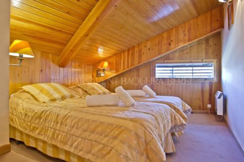 1 dormitorio con 1 cama grande en una habitación de madera en Apartarent 1500, en Baqueira Beret
