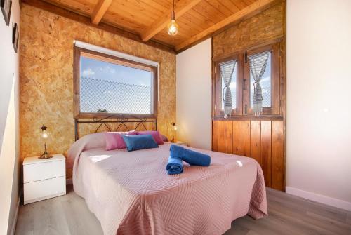 a bedroom with a bed and two windows at Casa Barranco de la Sal in Puerto del Rosario