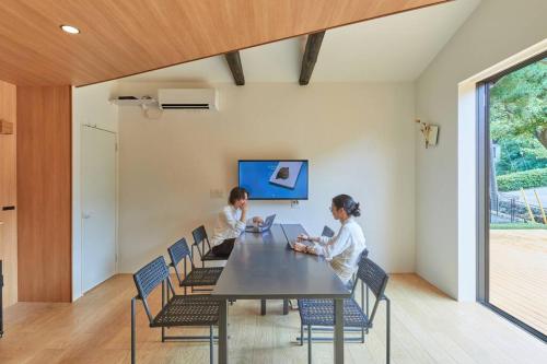 two children sitting at a table with laptops at VOYAN RESORT 伊豆MADOKA in Futo