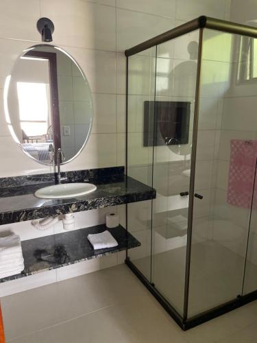 a bathroom with a glass shower and a sink at Pousada & Hospedagem Estação in Domingos Martins