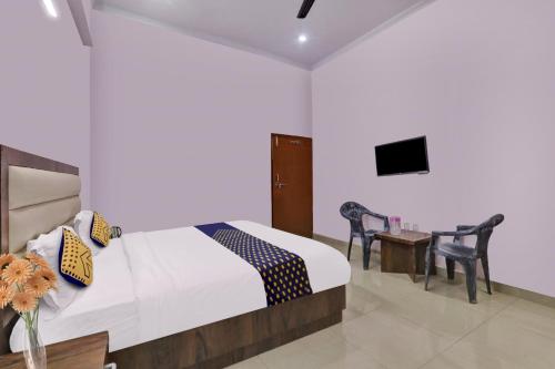 a bedroom with a bed and a table and chairs at SPOT ON Abhinandan Hotel And Restaurant in Pratāpgarh