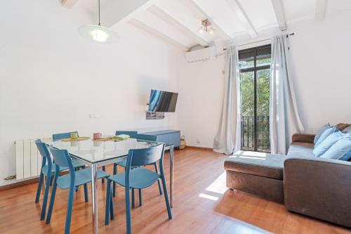 een woonkamer met een tafel en stoelen en een bank bij Charming Apartment In Clot in Barcelona