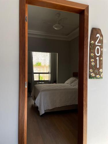 a bedroom with a bed and a mirror at Pousada & Hospedagem Estação in Domingos Martins