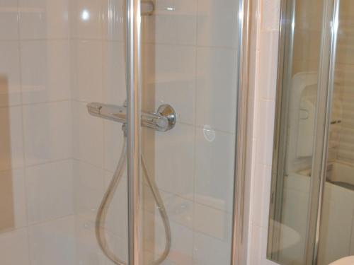 une cabine de douche avec une porte en verre et une douche. dans l'établissement Studio cabine 4 pers, balcon, pied des pistes, ascenseur - FR-1-557A-1, à La Ferrière