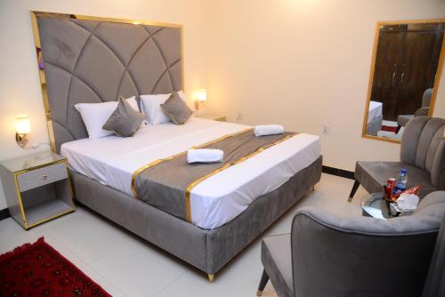 a bedroom with a large bed and a chair at Go Room Hotel Lahore in Lahore