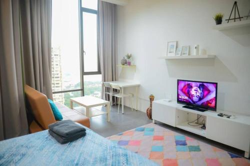 um quarto branco com uma cama e uma televisão em Garden at Empire Damansara em Petaling Jaya