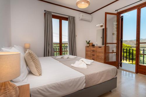 a bedroom with a large bed and a balcony at Villa Apelati in Keri
