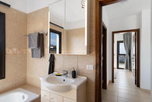ein Bad mit einem Waschbecken und einem Spiegel in der Unterkunft Casa Insitu in El Mojón