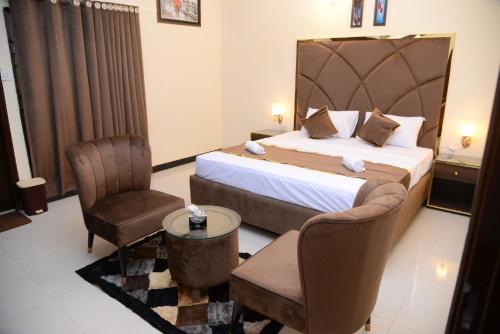 a hotel room with a bed and a chair at Go Room Hotel Lahore in Lahore