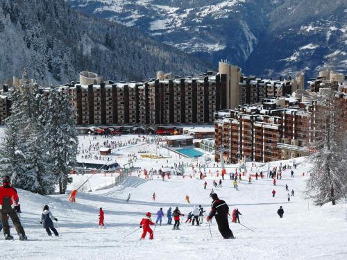 un groupe de personnes skier sur une piste de ski enneigée dans l'établissement Appartement rénové au centre, tout confort, animaux admis - FR-1-181-1947, à La Plagne Tarentaise