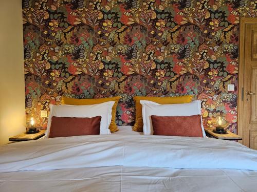 a bedroom with a large bed with a floral wallpaper at Les chambres de la Vaulx-Renard in La Gleize