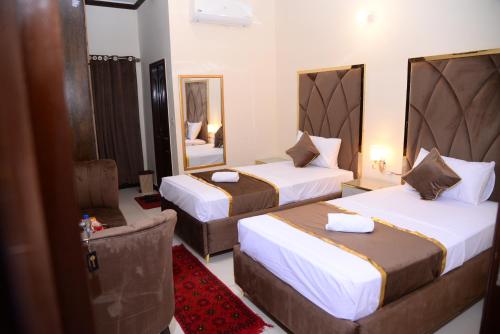 a hotel room with two beds and a mirror at Go Room Hotel Lahore in Lahore