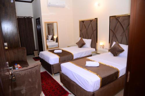 a hotel room with two beds and a mirror at Go Room Hotel Lahore in Lahore