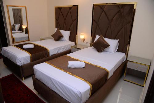 a hotel room with two beds and a mirror at Go Room Hotel Lahore in Lahore