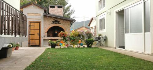 a yard with a house with a door and a lawn at ANA in Gračac