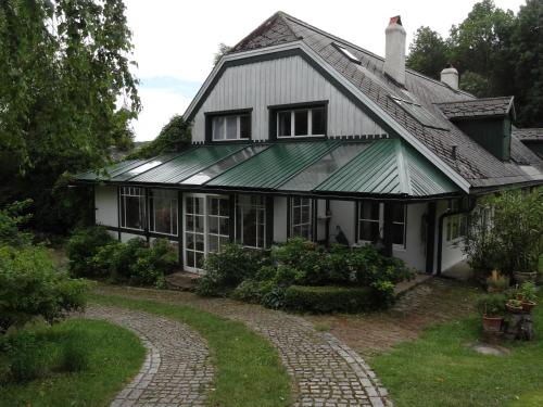 uma casa branca com um telhado verde e uma entrada em Landhof Ott em Wolfsgraben