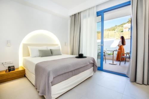 a bedroom with a bed and a balcony at euphoria boutique hotel in Chrysi Ammoudia