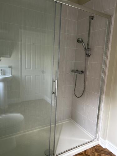 a bathroom with a shower with a glass door at The Lodge at Salhouse in Norwich