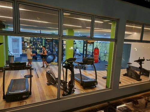 ein Fitnessstudio mit mehreren Personen, die auf elliptischen Maschinen trainieren in der Unterkunft Elegant Studio at Grass Residences 1-5 persons only, Quezon City in Manila