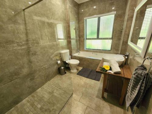 een badkamer met een douche, een wastafel en een toilet bij Villa A23 - Selborne Golf Estate in Pennington