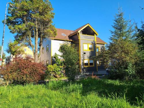 a large yellow house with a tree in the yard at Queen's Cave By Staysville in Stavanger
