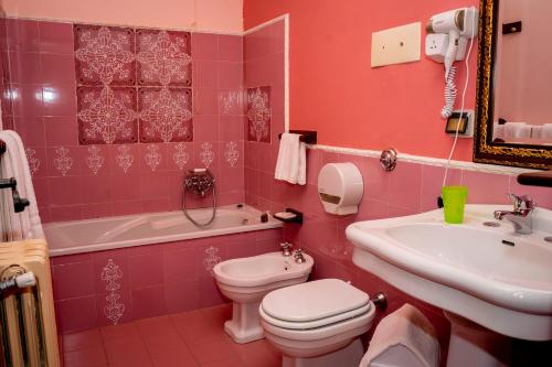 een roze badkamer met een toilet en een wastafel bij Casale Villa Rainò in Gangi