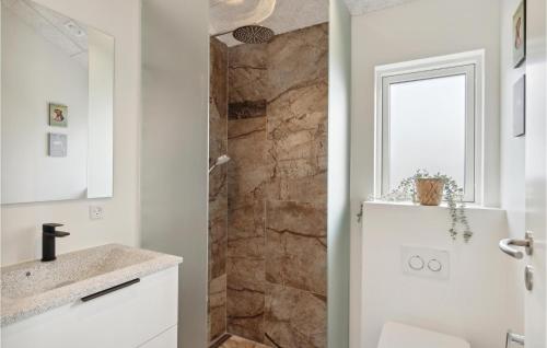 y baño con ducha y pared de piedra. en 4 Bedroom Stunning Home In Strandby en Strandby