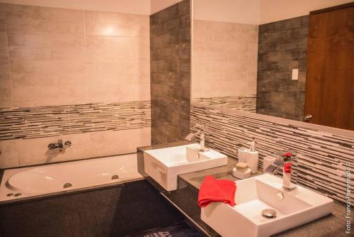 ein Badezimmer mit Waschbecken und Badewanne in der Unterkunft La Esquina - hermosa casa en Termas del Daymán con Piscina in Termas del Daymán