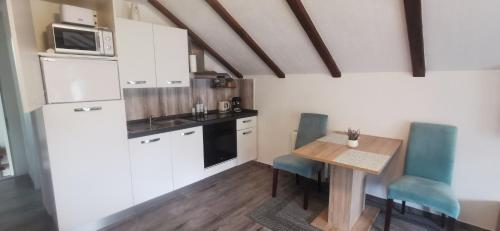 a small kitchen with a table and a microwave at ANA in Gračac