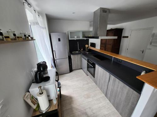 eine kleine Küche mit einem Kühlschrank und einer Arbeitsplatte in der Unterkunft Magnifique T3 Guéret in Guéret