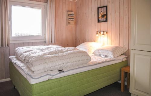 a bedroom with a bed with two pillows on it at 4 Bedroom Gorgeous Home In Hvide Sande in Havrvig
