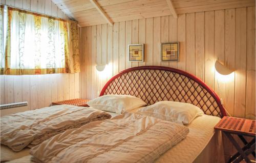 a large bed in a room with wooden walls at Nice Home In Hvide Sande With Kitchen in Havrvig
