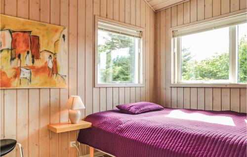 a bedroom with a purple bed and two windows at 4 Bedroom Cozy Home In Hvide Sande in Havrvig