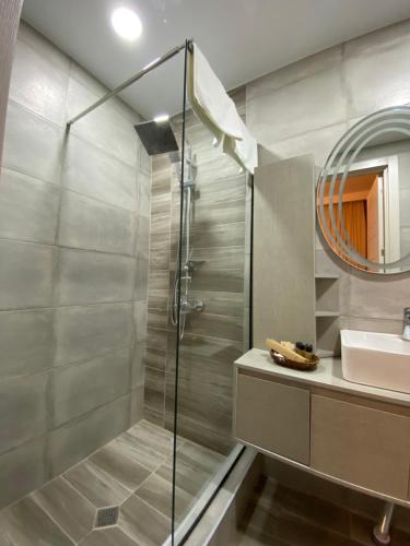 a bathroom with a shower and a sink and a mirror at Kera Rooms in Tʼelavi