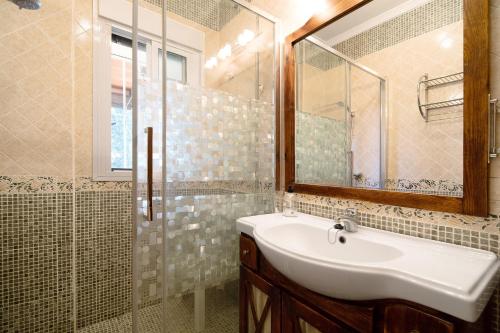 a bathroom with a sink and a glass shower at Villa Juani in Chiclana de la Frontera