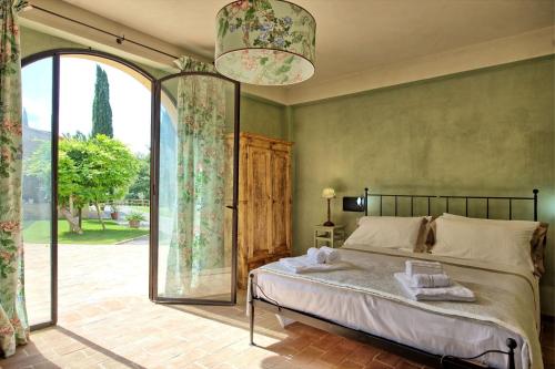 a bedroom with a bed and a large window at La Pimpinella di Semifonte in San Donnino