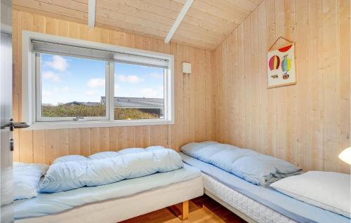 ヴィデ・サンデにあるAmazing Home In Hvide Sande With 3 Bedrooms, Sauna And Wifiの窓の前にベッド2台が備わる客室です。