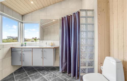 ヴィデ・サンデにあるGorgeous Home In Hvide Sande With Saunaのバスルーム(洗面台、トイレ付)、窓が備わります。