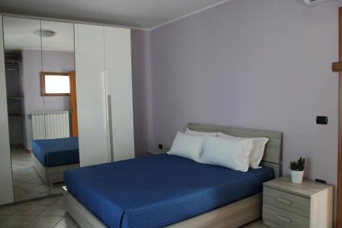 - une chambre avec un lit bleu et un miroir dans l'établissement La collina degli ulivi, à Conocchia