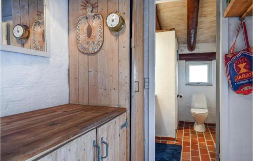 een badkamer met een toilet en klokken aan de muur bij 4 Bedroom Beach Front Home In Hvide Sande in Bjerregård