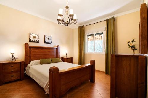 a bedroom with a bed and a chandelier at Villa Juani in Chiclana de la Frontera