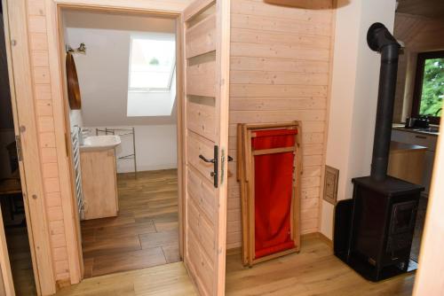 a door to a bathroom with a wood stove at Apartament Pod Świerkami in Małe Swornigacie