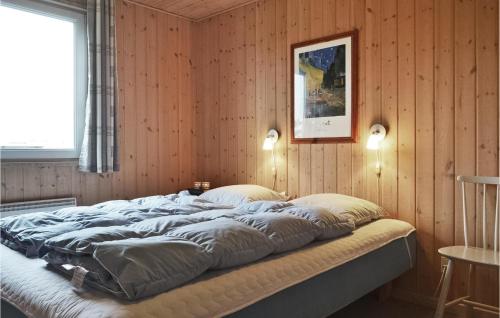 BjerregårdにあるToppeの木製の壁の客室の大型ベッド1台